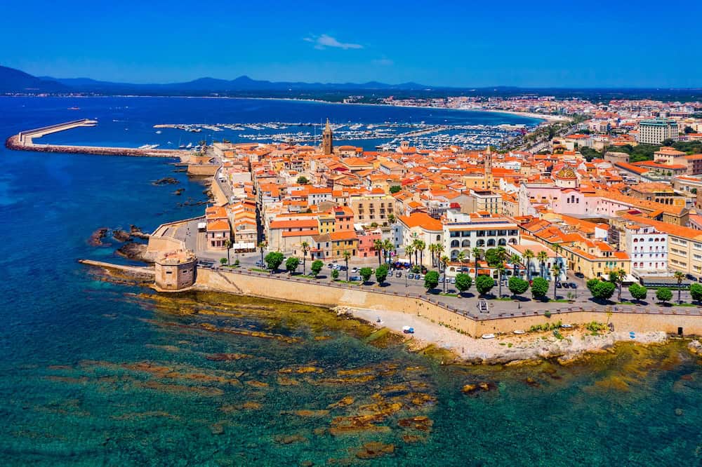 Aerial view over Alghero old town, cityscape Alghero view on a beautiful day with harbor and open sea in view. Alghero, Italy. Panoramic aerial view of Alghero, Sardinia, Italy. Alghero Sardinia